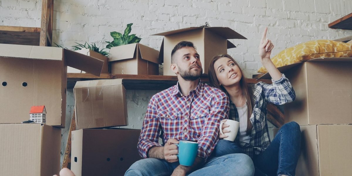 A couple thoughtfully considering different apartment types and future living arrangements for their new home.