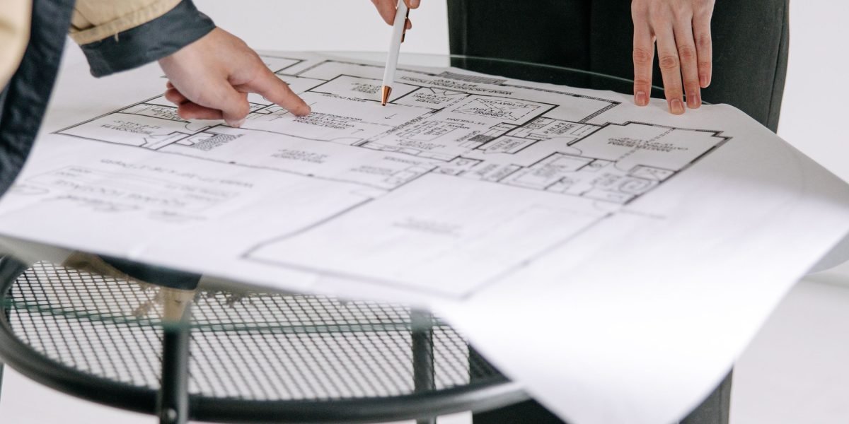 A professional real estate agent discusses property options with a client in a modern office setting.