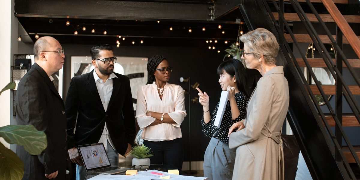 A diverse group of individuals engaging in a conversation about accessible investment opportunities.