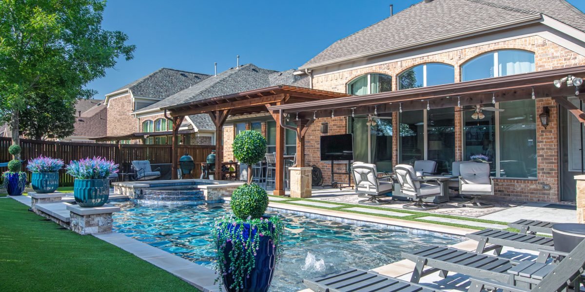 A family enjoying quality time together in a spacious, green garden of a luxury villa.