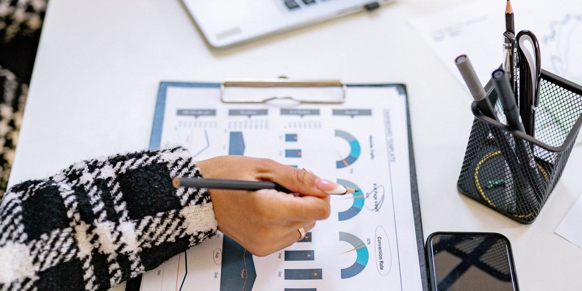 A person intently reviewing charts and graphs, representing the analysis of market trends and economic factors.