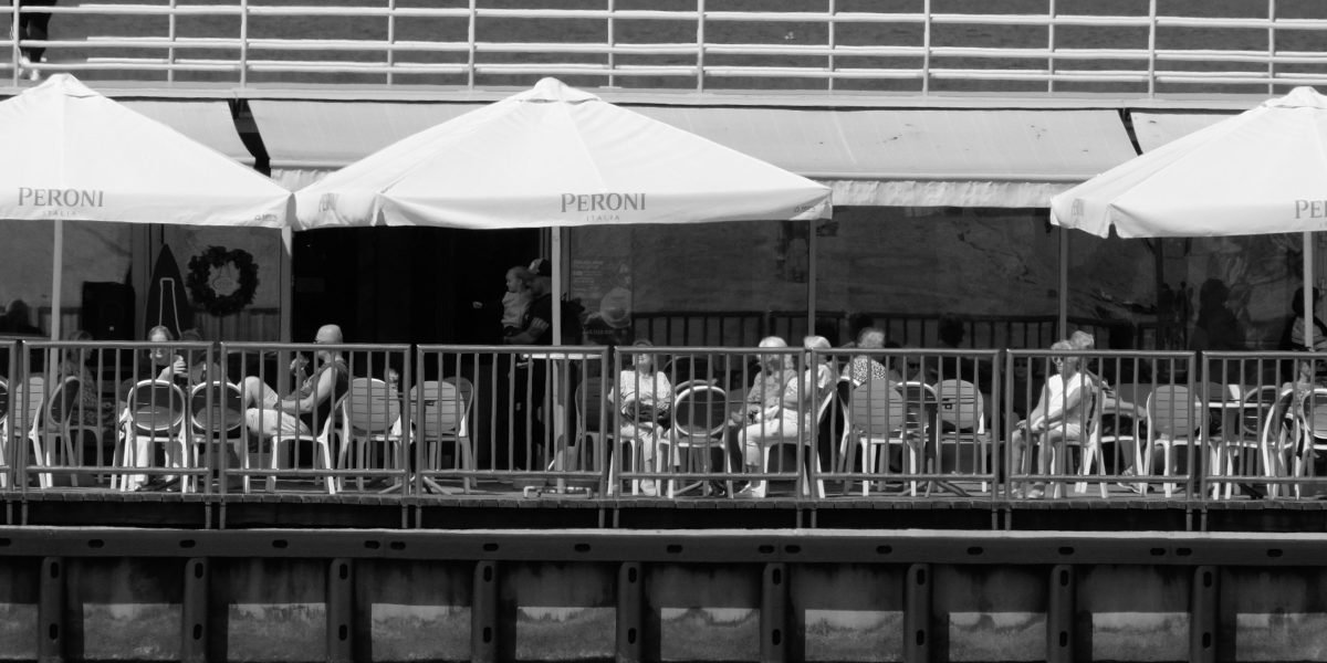People enjoying a meal at a vibrant waterfront cafe, reflecting the luxurious lifestyle of Dubai Marina.