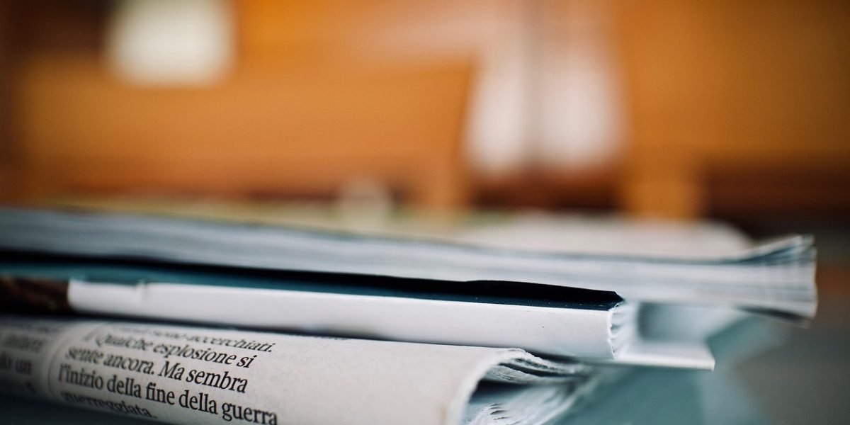 An investor thoughtfully reviews news headlines, considering market volatility.