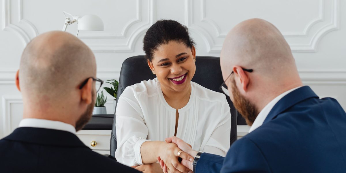 Professionals shaking hands, symbolizing successful consultation and agreement in navigating real estate complexities.