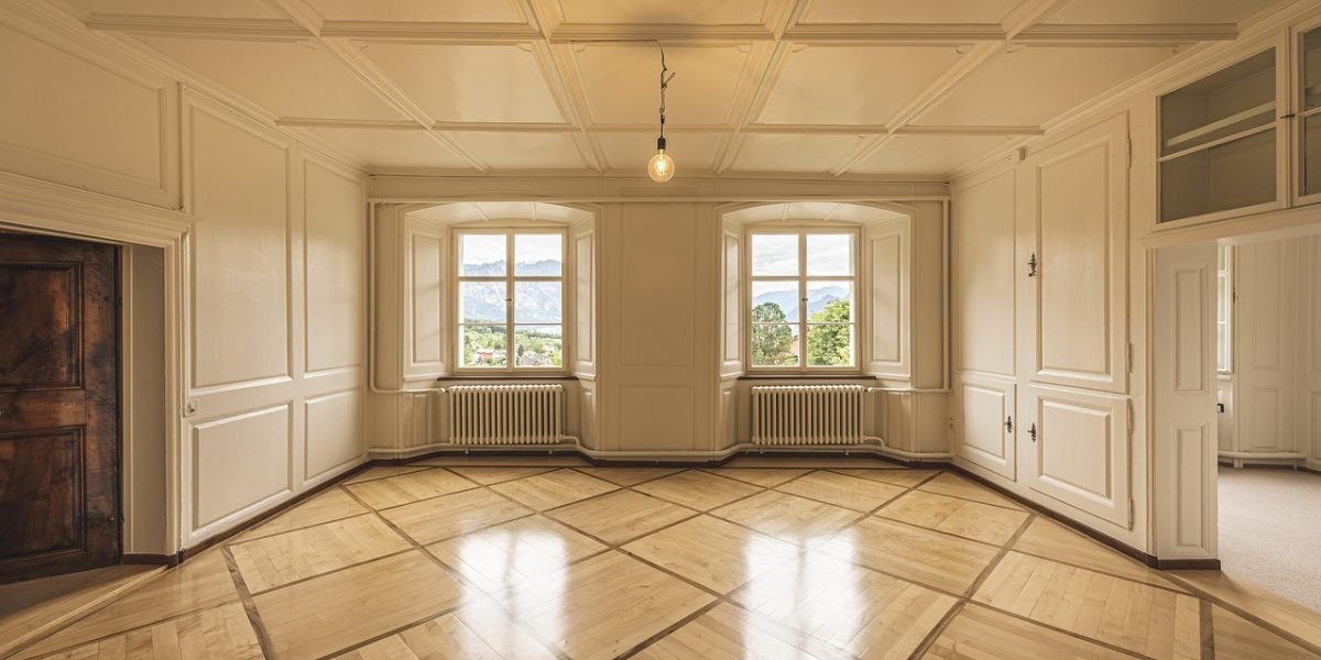 A real estate agent guiding a couple through a spacious property, representing the search for a family home in Sharjah.