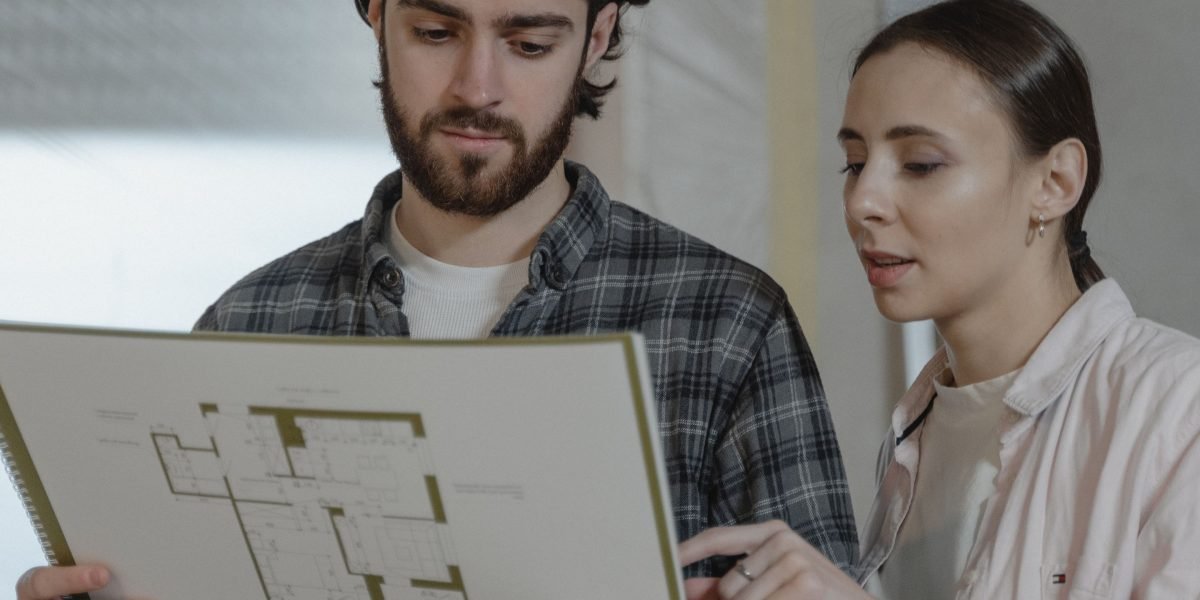 A couple carefully reviews architectural plans, symbolizing the thoughtful process of selecting the ideal villa layout for their family.