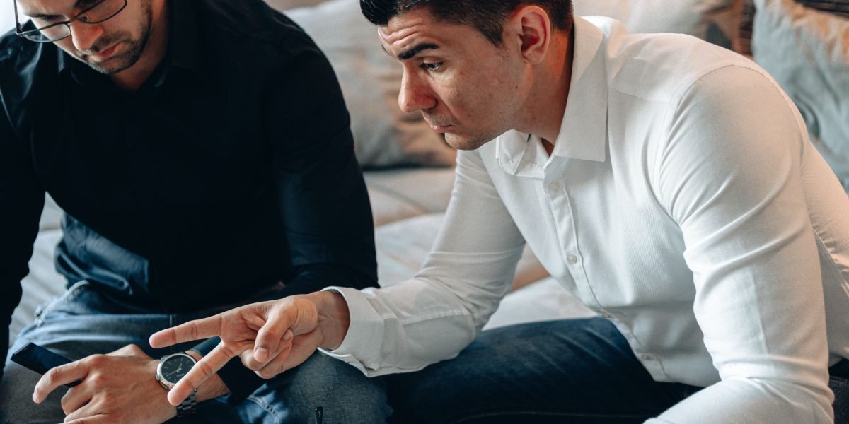 A confident investor discusses luxury property options with a trusted advisor in a modern setting.