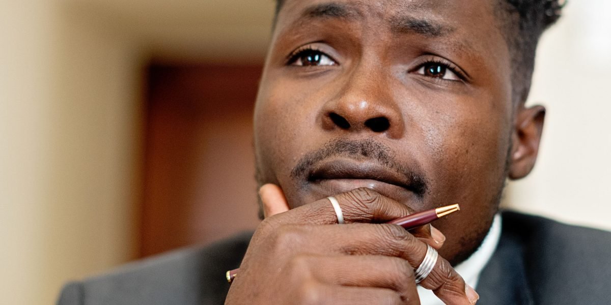 A person thoughtfully considering options, symbolizing the careful decision-making process when selecting a brokerage.