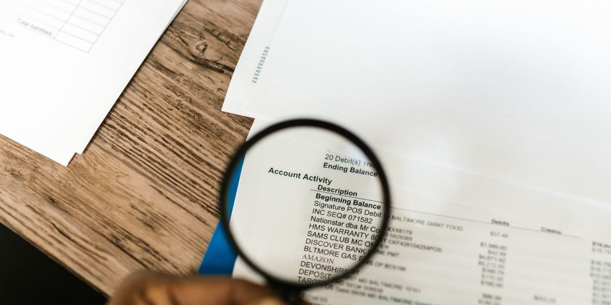 A person intently reviews financial documents and a calculator, planning for home costs.